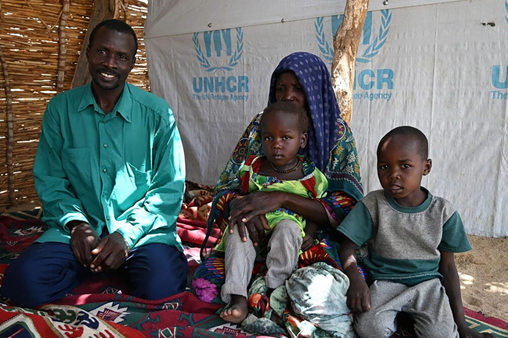 A family sits in a tent at their shelter in a refugee camp in eastern Chad.