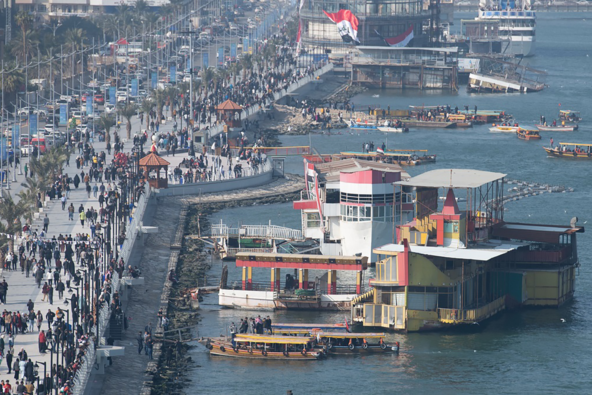 Iraqi Port of Basra's waterfront crowded with people and infrastructure.