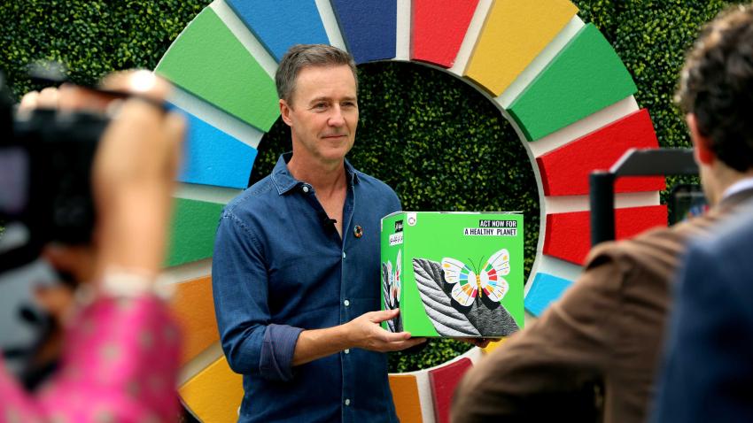 Edward Norton holds the ActNow cube outside the SDG Media Zone