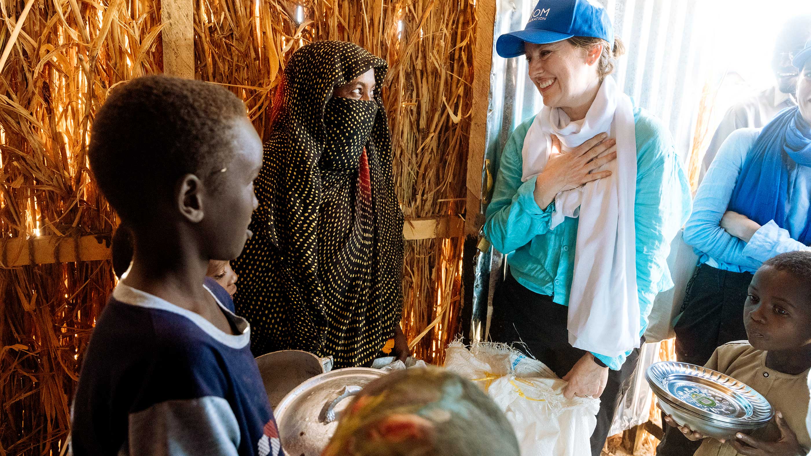 Amy visits a family inside a hut made of straw