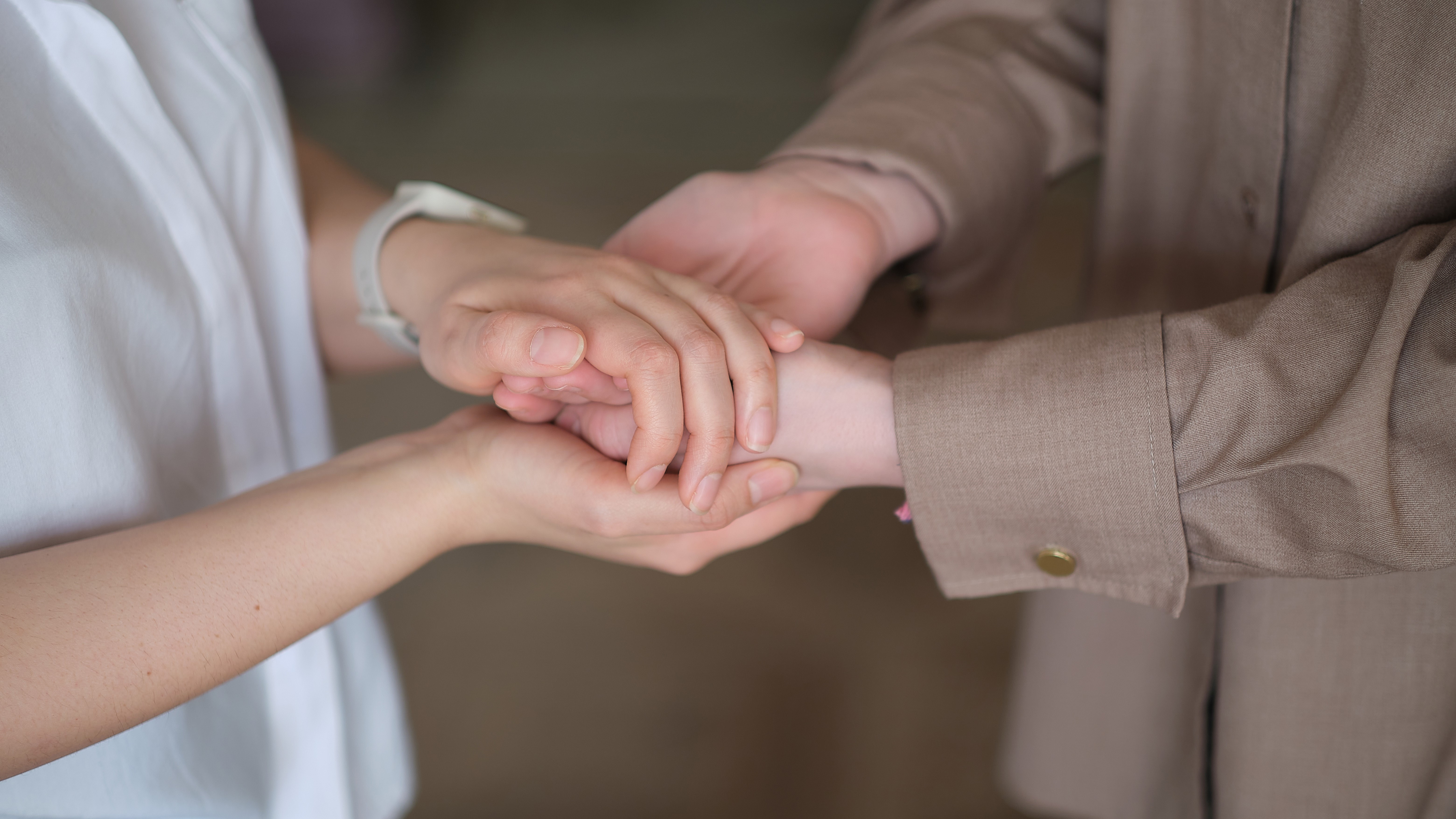 Psychologist holds hands with patient