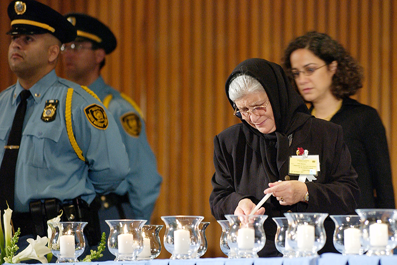 A relative of a fallen staff member lights candles during the observance of the first anniversary of the attack at the UN headquarters in Baghdad.