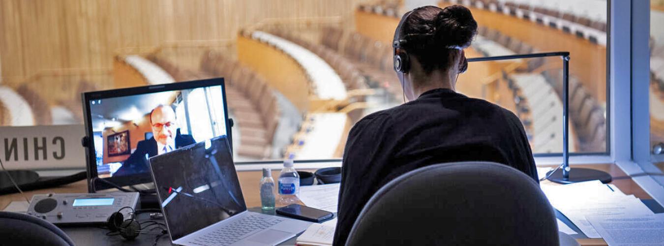 An interpreter, seen from behind, working in a booth at the UN in New York.