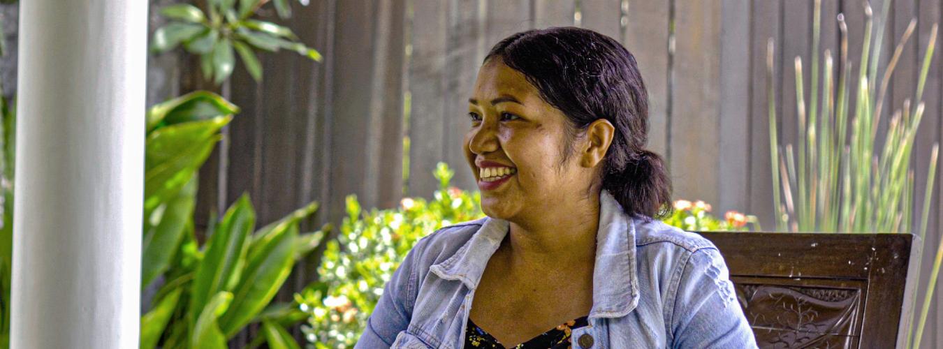 smiling woman sitting in a garden