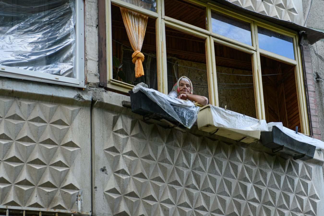 elderly woman at blown out window