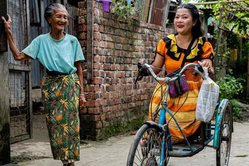 A woman rides an adaptive tricycle.