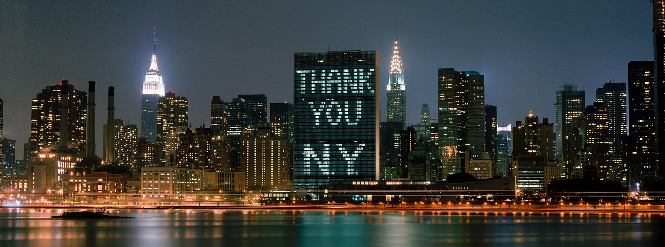 United Nations Secretariat building in New York, seen from East River.  Its windows are illuminated with the words 'THANK YOU NY'