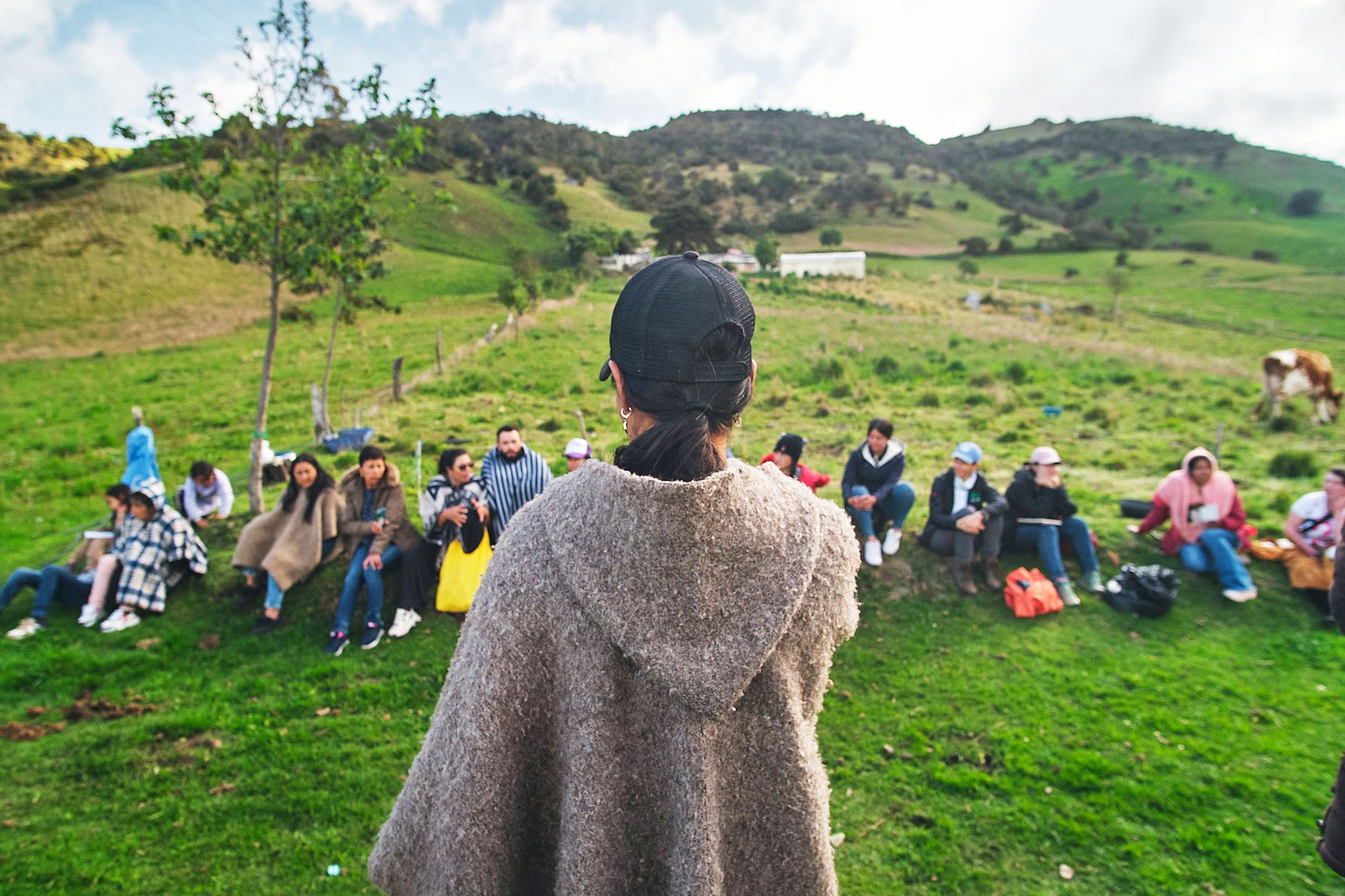 woman standing in front of group of people seated outside