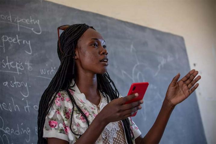 girl in front of blackboard reciting poem