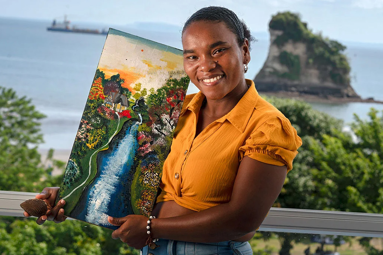 A woman shows a bowl of harvested piangua and a painting of the mangrove estuaries where it is collected. 