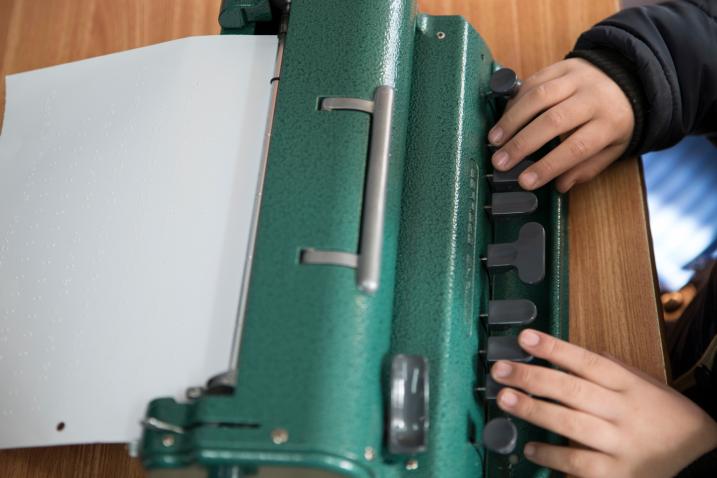 7-year-old Jihad Atrash, who is blind, uses a Braille device in class (State of Palestine, 2017). Photo UNICEF/Ahed Izhiman